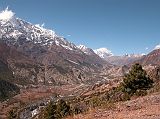 Annapurna 12 08 Looking Towards Manang From Ghyaru Looking up the valley toward Manang from Ghyaru, Annapurna III (7555m) had its head in the clouds. Just poking up behind Annapurna III was Gangapurna (7455m), and beyond Manang the Grande Barri�re was in view. The airstrip at Hongde is visible in the lower centre.